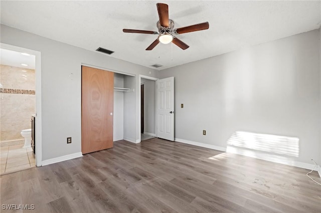 unfurnished bedroom with visible vents, baseboards, and wood finished floors