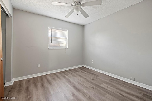 unfurnished bedroom featuring baseboards, a textured ceiling, and wood finished floors