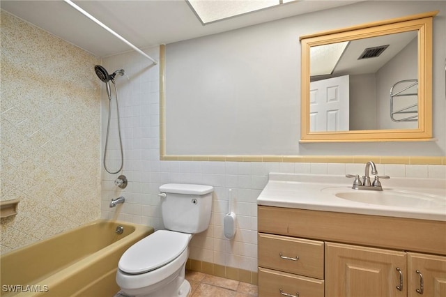 full bath featuring visible vents, a wainscoted wall, toilet, vanity, and tile walls