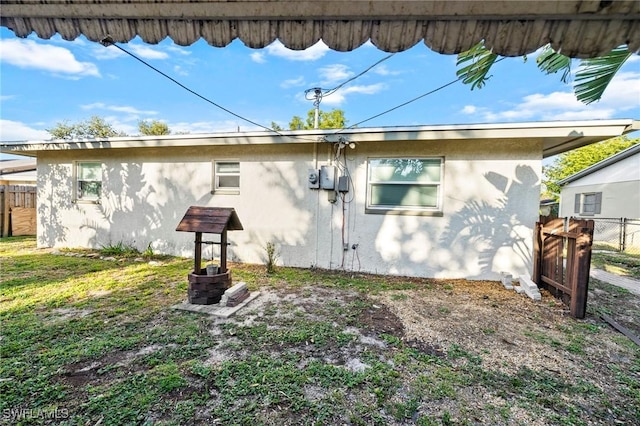 view of side of property featuring stucco siding and fence