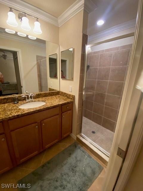 bathroom featuring tile patterned flooring, a tile shower, vanity, and crown molding