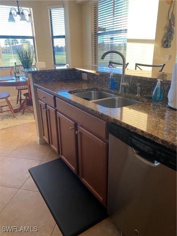 kitchen featuring a wealth of natural light, a sink, light tile patterned floors, and stainless steel dishwasher