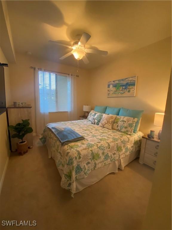 bedroom with a ceiling fan and light carpet