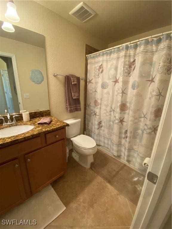 bathroom with vanity, a shower with curtain, visible vents, tile patterned floors, and toilet