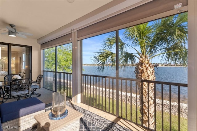 sunroom / solarium with a water view and ceiling fan