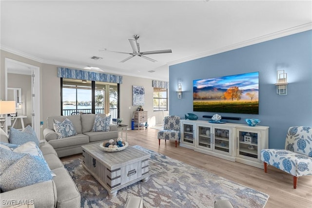 living room featuring ceiling fan, visible vents, wood finished floors, and ornamental molding