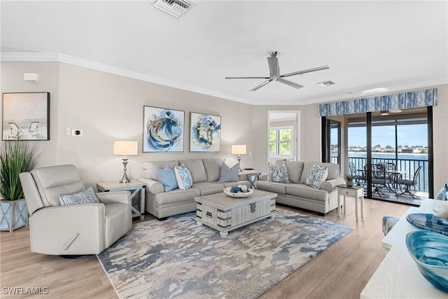 living area with visible vents and crown molding