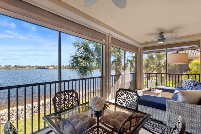 sunroom featuring a water view and a ceiling fan