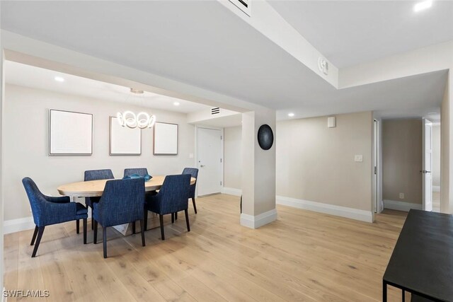 dining space with an inviting chandelier, light wood-style flooring, and baseboards