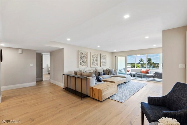 living area featuring light wood-style flooring, recessed lighting, and baseboards