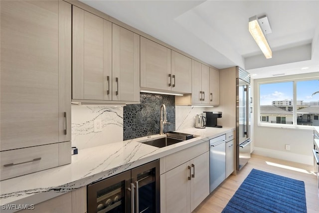 kitchen featuring wine cooler, decorative backsplash, appliances with stainless steel finishes, light wood-style floors, and a sink