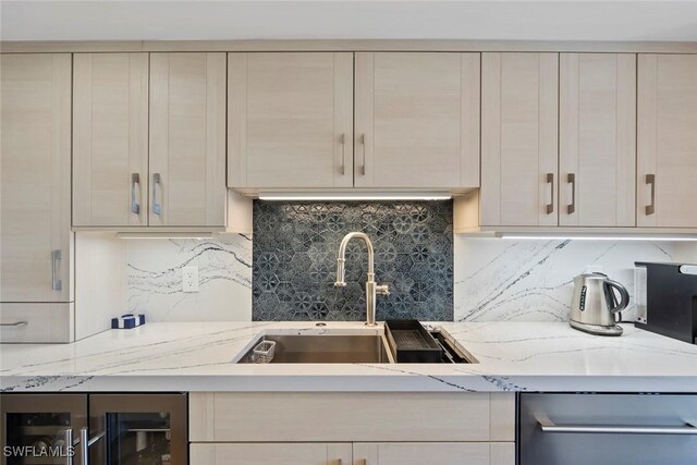 kitchen with a sink, light stone counters, backsplash, stainless steel dishwasher, and wine cooler