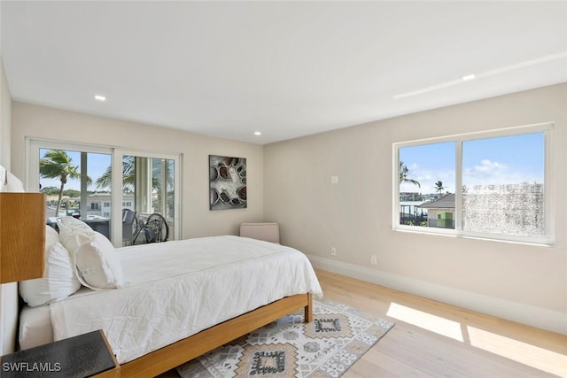 bedroom with recessed lighting, baseboards, wood finished floors, and access to outside