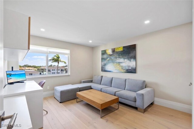 living room with recessed lighting, light wood-style floors, and baseboards