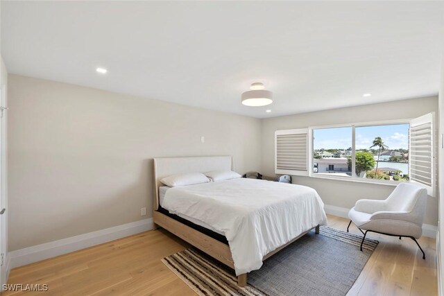 bedroom with recessed lighting, light wood-type flooring, and baseboards