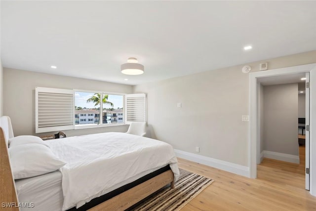 bedroom with recessed lighting, light wood-type flooring, and baseboards