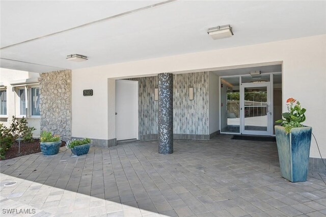 property entrance featuring stucco siding and a patio area