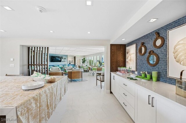 kitchen with recessed lighting, marble finish floor, and white cabinetry