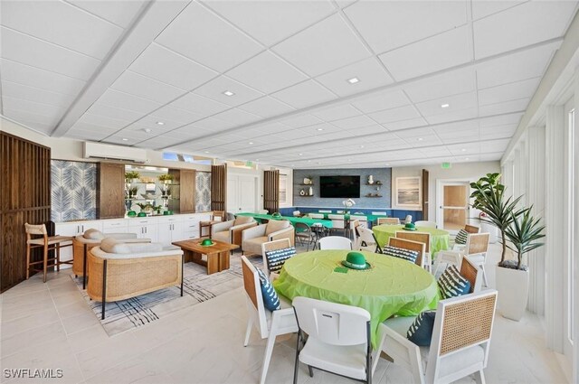 dining space with a drop ceiling, recessed lighting, and a wall unit AC