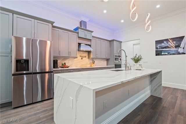 kitchen with under cabinet range hood, a center island with sink, stainless steel refrigerator with ice dispenser, and ornamental molding