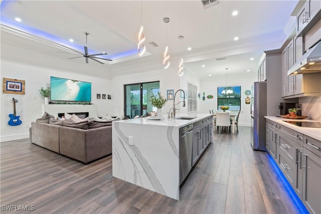 kitchen with dark wood-style floors, appliances with stainless steel finishes, gray cabinetry, and a sink