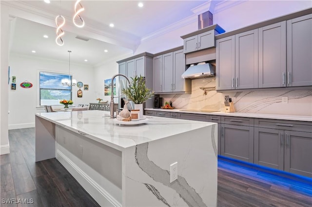 kitchen featuring tasteful backsplash, gray cabinetry, dark wood-type flooring, ornamental molding, and exhaust hood