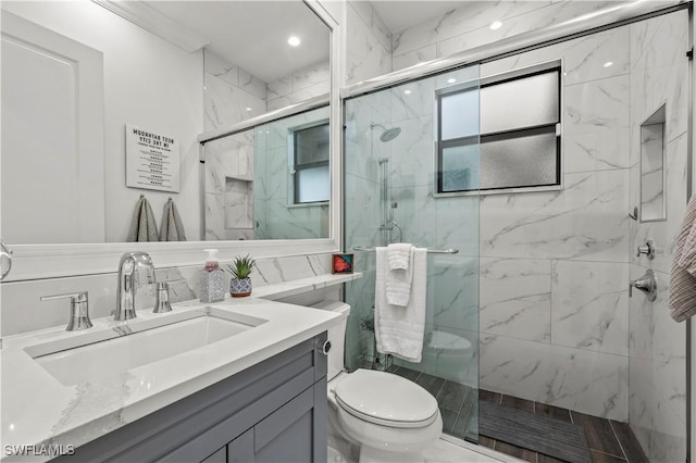 bathroom with vanity, toilet, and a marble finish shower