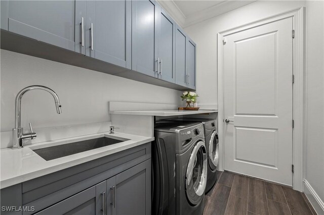 laundry area featuring crown molding, wood tiled floor, cabinet space, independent washer and dryer, and a sink