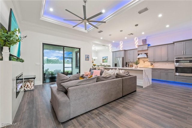 living room with visible vents, crown molding, ceiling fan, and dark wood-style flooring