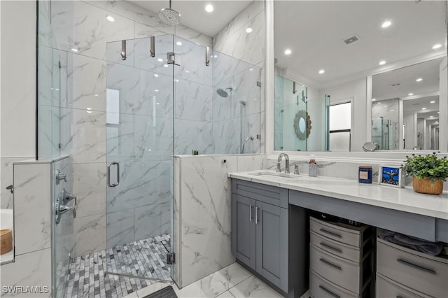 full bath with a marble finish shower, vanity, recessed lighting, marble finish floor, and tile walls