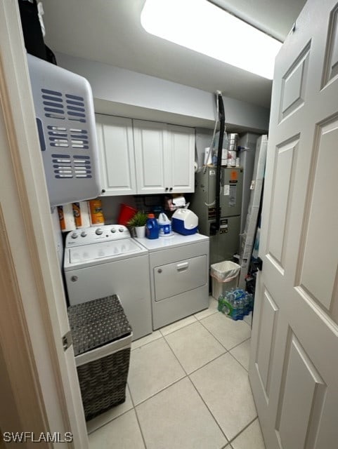 laundry room featuring light tile patterned floors, cabinet space, and washer and dryer