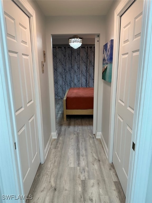 hallway featuring baseboards and wood finished floors