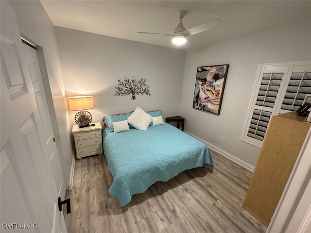 bedroom with a ceiling fan, wood finished floors, and baseboards