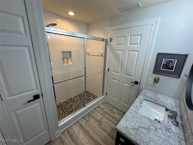 bathroom featuring vanity, wood finished floors, visible vents, recessed lighting, and a stall shower