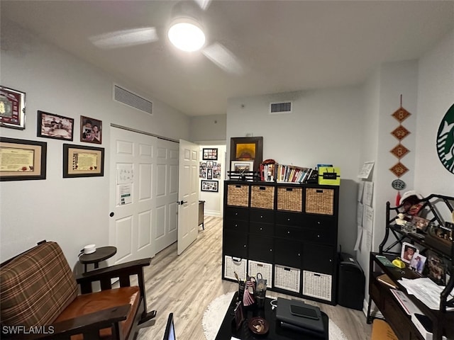 office space with visible vents, light wood-style floors, and a ceiling fan