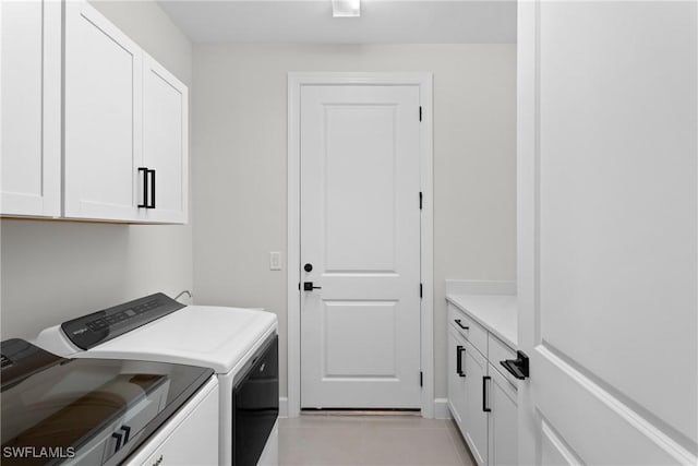 washroom with light tile patterned floors, cabinet space, and independent washer and dryer