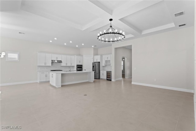 unfurnished living room with visible vents, baseboards, coffered ceiling, and a chandelier