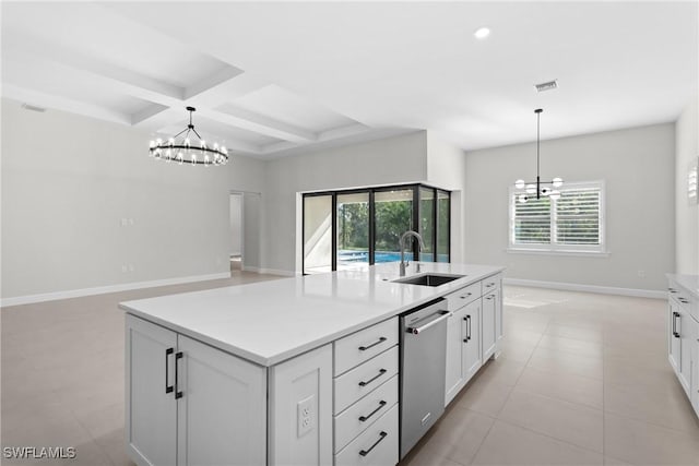 kitchen featuring white cabinetry, stainless steel dishwasher, an inviting chandelier, and a sink