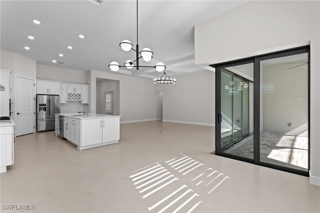 kitchen with a chandelier, light countertops, white cabinets, stainless steel appliances, and a sink