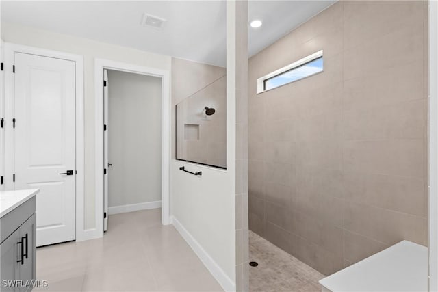 bathroom with visible vents, a walk in shower, vanity, and baseboards