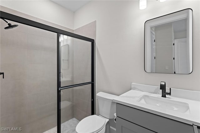 bathroom featuring a stall shower, toilet, and vanity