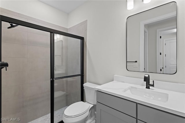 full bathroom with vanity, a shower stall, and toilet