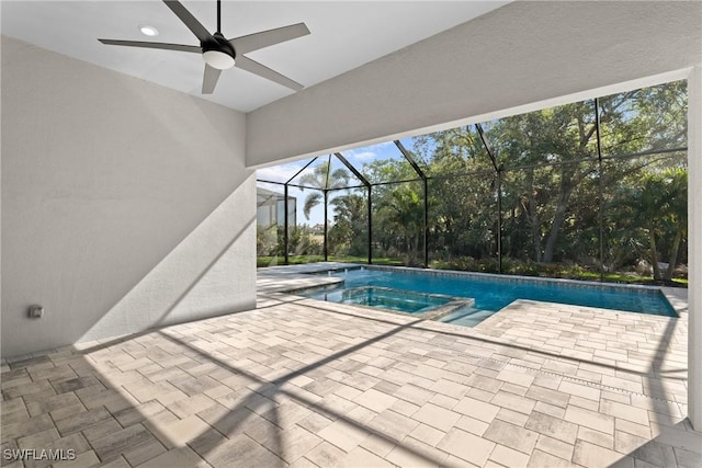 view of pool featuring a patio, a ceiling fan, a pool with connected hot tub, and a lanai