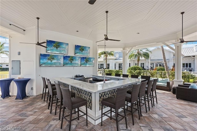 view of patio with outdoor wet bar, an outdoor hangout area, electric panel, and ceiling fan