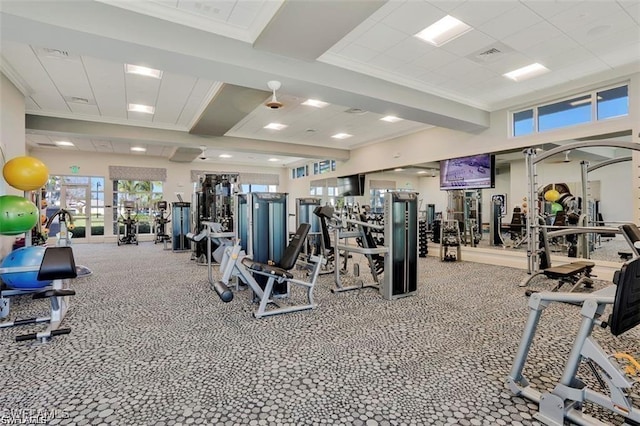 exercise room featuring carpet flooring, crown molding, and visible vents