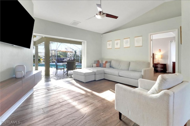 living room with visible vents, lofted ceiling, a ceiling fan, and hardwood / wood-style flooring