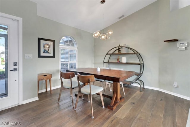 dining room with a wealth of natural light, wood finished floors, and vaulted ceiling