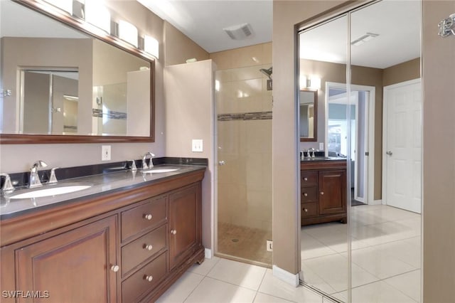 bathroom featuring tile patterned floors, a stall shower, and a sink