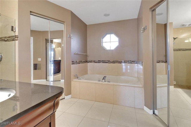 full bath featuring tile patterned floors, a garden tub, a stall shower, and vanity