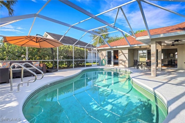 pool featuring glass enclosure, a ceiling fan, and a patio area